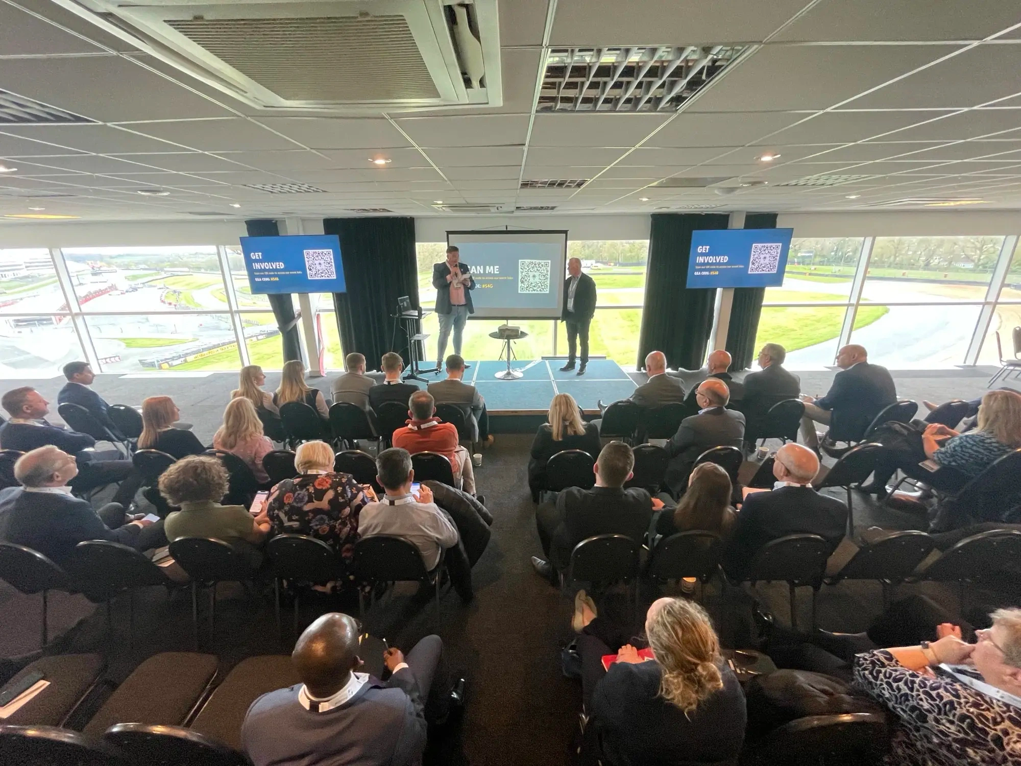 A group of people presenting in front of a crowd of people