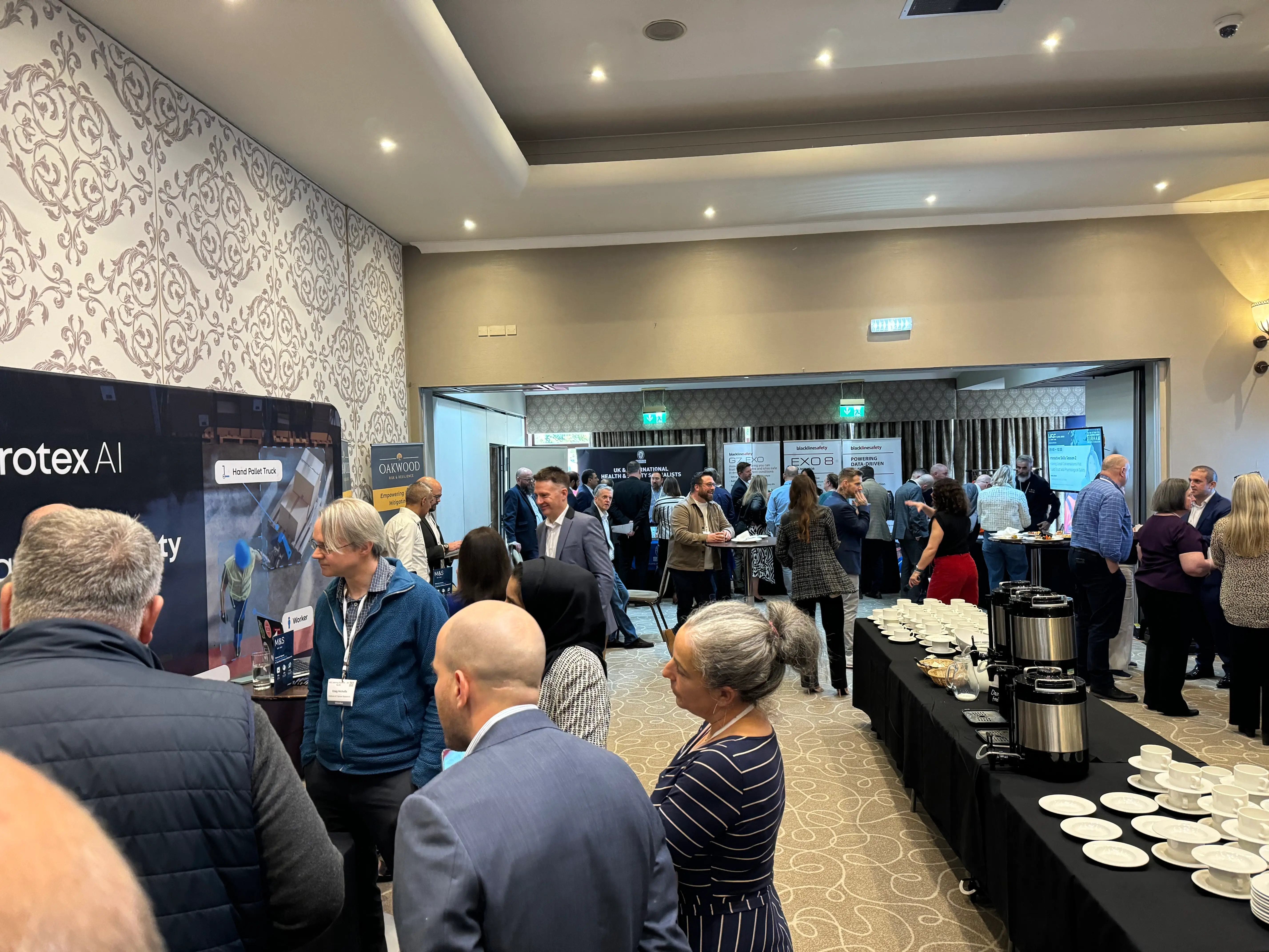 A group of people queuing waiting for a coffee machine in formal business attire.